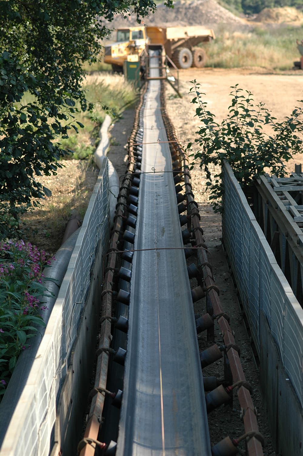Inclined belt conveyor moving bulk material from a lower loading point
